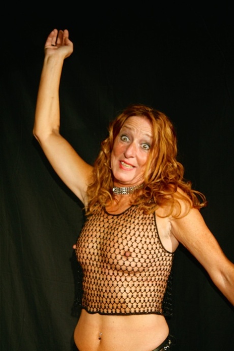 Redheaded MILF Kyra Nylons Flaunts Her Titties Through A Fishnet Shirt