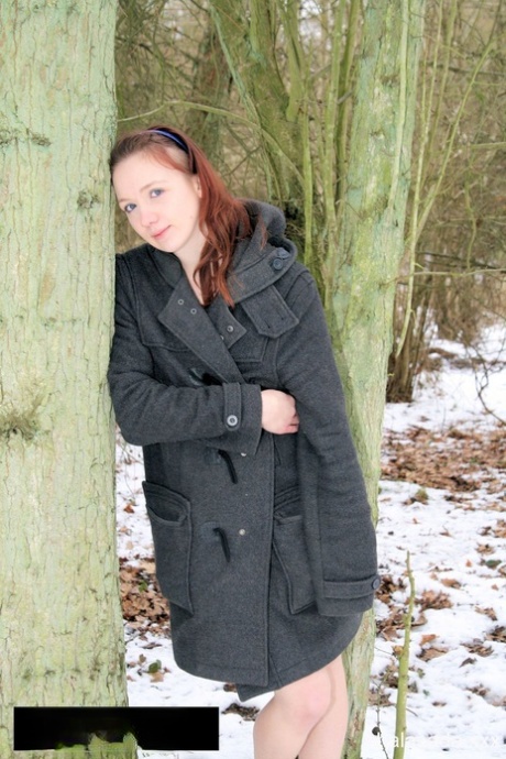 In the snow, amateur MILF dressed in a seductive outfit, including a coat and running shoes, is seen.