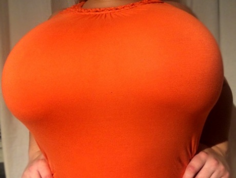 A tight dress by Natasha Crown exposes her large, fatty chest area.