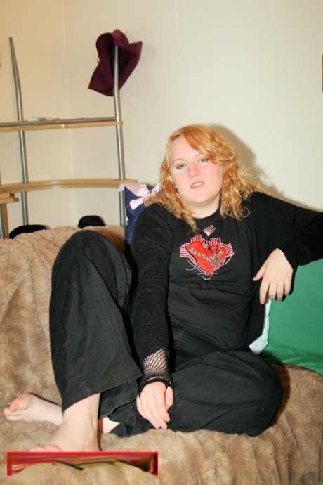 A black bra shows her cleavage while the sweatshirt is removed by redheaded fat.