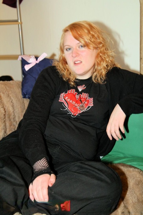 After stripping off her sweatshirt, the redheaded fatty displays her bust in a black bra.
