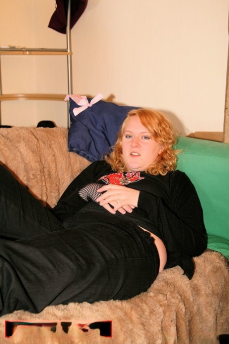 Redheaded fatty exposes her chest through a black bra and removes the sweatshirt.