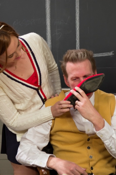 The feet of Maddy O'Reilly and Jodi Taylor, the students in their class, are licked by their teacher.