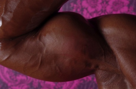 Black bodybuilder Yvette Bova displays her massive breasts and muscle definition.