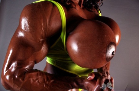 The huge melons: Muscular ebony-covered, woman named Yvette Bova is shown lifting weights.