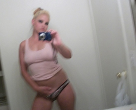 Blondy who is chubby takes pictures of her reflection in the mirror, showing off big tits and antlers.