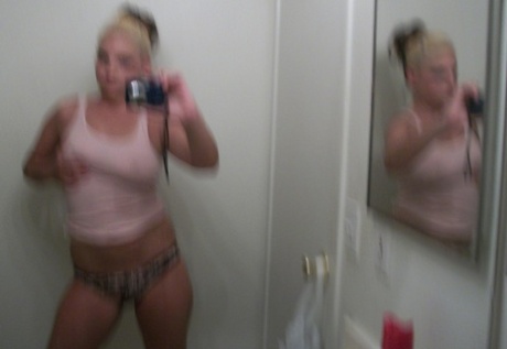 The plump blonde reflects in her reflection by taking selfies of her prominent breasts and buttocks.