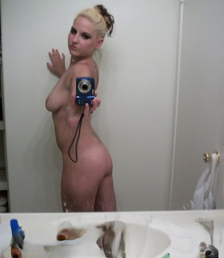 Blondy with big breasts and buttocks capture self-portrait in a mirror selfie.