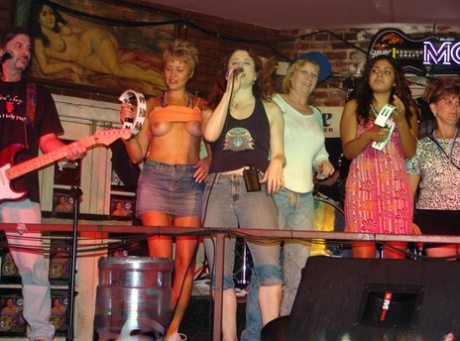 A night bar features Tracy Lick, an amateur swinger with big tits, who unveils her attributes to the crowd.