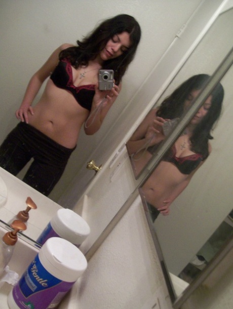 Teen with dark hair takes selfies in the mirror showing her bare buttocks and body.