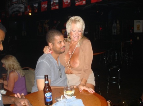 Amateur swingers flaunt her massive breasts at a wild gathering in the bar.