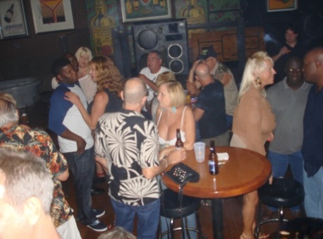 Amateur swingers display her massive breasts during a wild celebration at the bar.