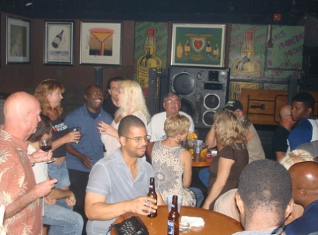 Her large breasts are exhibited by amateur swingers during an exciting event at the bar.