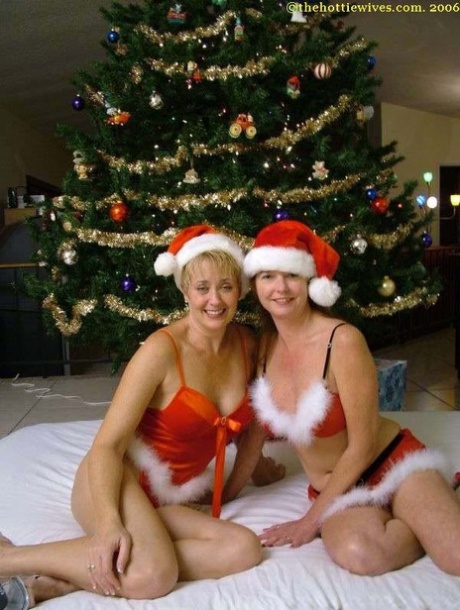 In Xmas attire, amateur swingers playfully in front of a Christmas tree to cheer on each other.