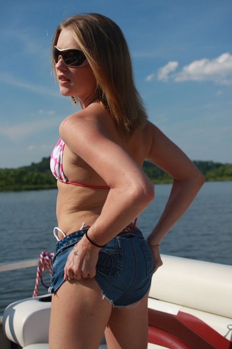 Cute amateur teen in a sexy bikini posing on a boat and touching herself