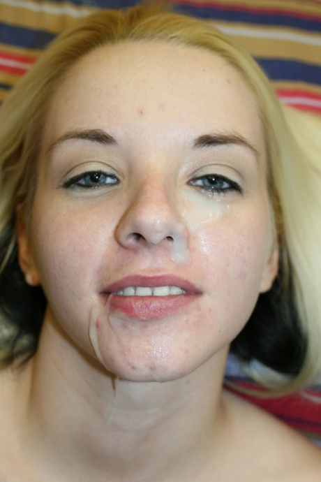 Close up: A blonde amateur shows a creampied pink pussy and facial cumshot on her right eye.