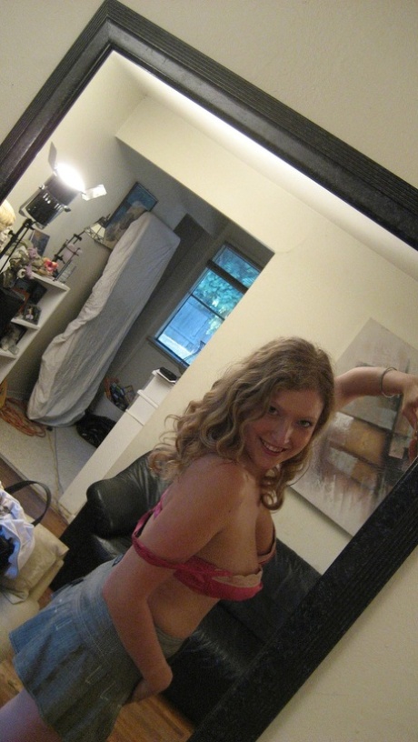 Sweet amateur girl Tracy stripping and staring at her reflection with a pair of glasses in front of the mirror.