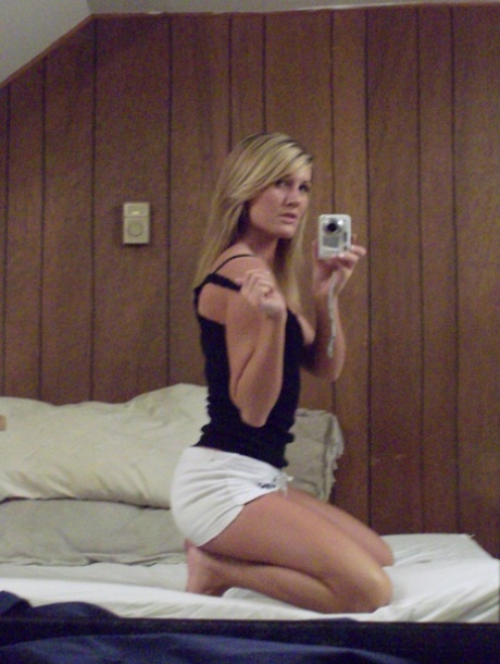 While filming, amateur blonde Adrina Scott takes a photo of herself stripping and looking at her reflection in the mirror.