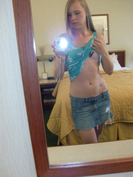 Selfies: Ashley Ross, a dorky amateur doll, takes her pictures as she strips and poses in front of the mirrors.