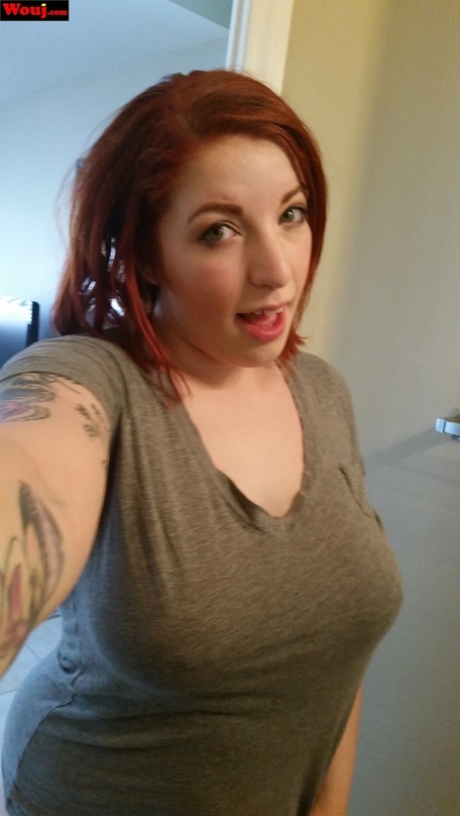 The redhead WouJ is teasing with her juicy tits and taking selfies with her full-figured figure.