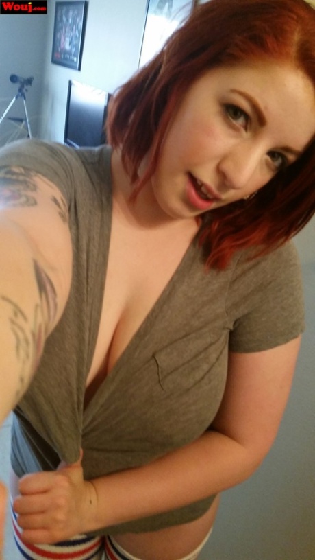 A full-figured redhead named WouJ is seen taking selfies with her juicy tits and taunting her friends.