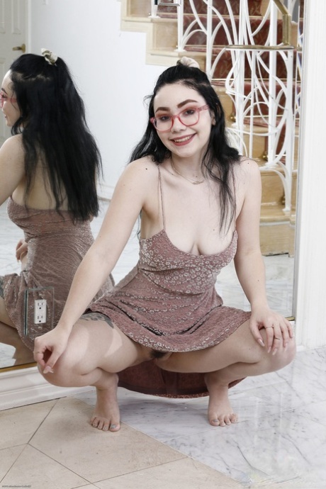 A young woman named Leena Lux, who has black hair and big tits, undresses and poses in the nude.