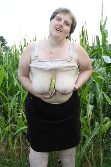 The naked plump European girl Tina C undresses in a corn field while masturbating.