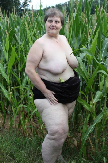 While in a corn field, Plump European Tina C engages in the act of stripping off and then masturbates while her mature clitoris is developed.