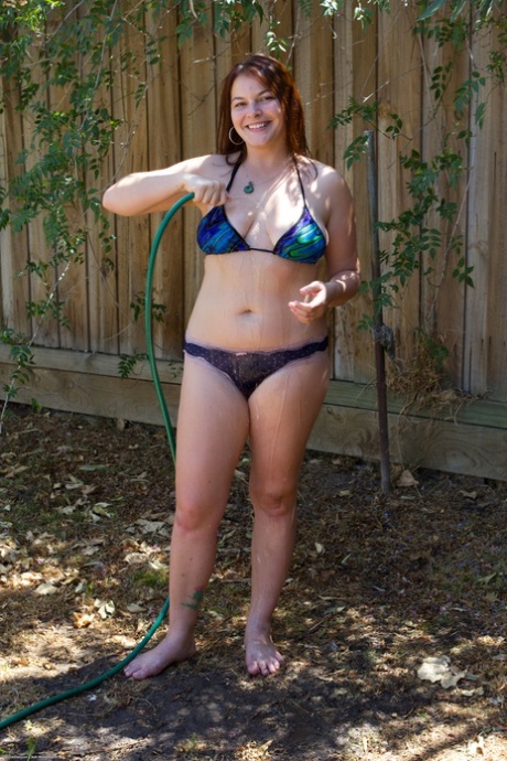 While playing with a water hose outside, Sequoia, the chubby babe, removes her bikini.