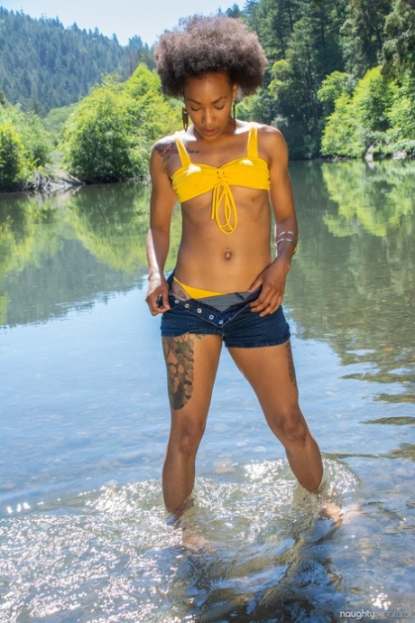 Афроамериканка Никки Дарлинг выставляет свое волосатое татуированное тело в реку