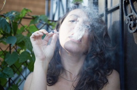 As she poses in the nude, Nikki Silver showcases her skills by smoking a cigar.
