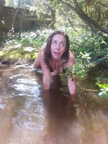 In a bikini, Nikki Silver showcases her hairy pits in the river.