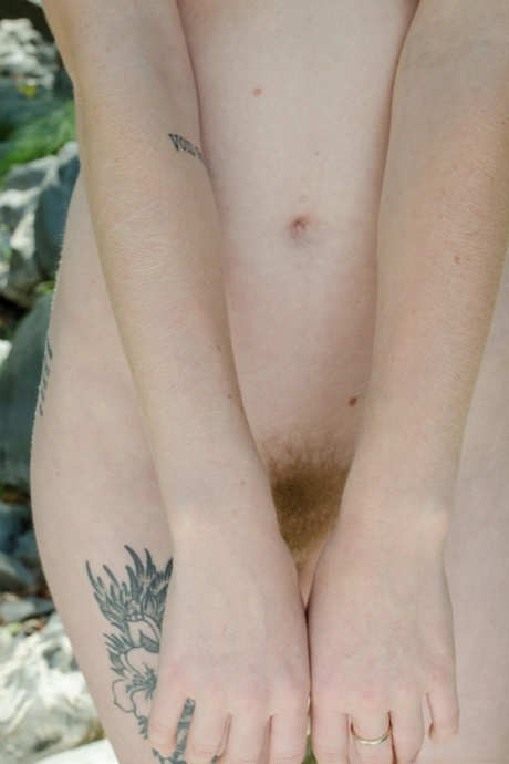 A natural foreground in which Ivy Blair, a beauty with golden hair, exposes her tattooed body and poses with her hair.