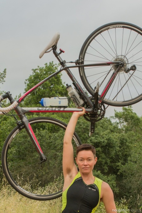 Jiz Lee, an amateur bicyclist, displays her hairy body while stripping in nature.