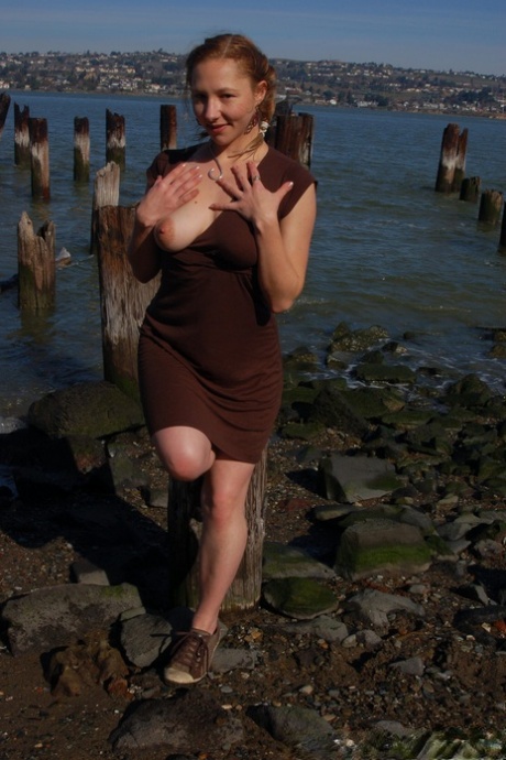 After removing her dress, amateur Maggie Mayhem plays with all of her breasts while out in the open.