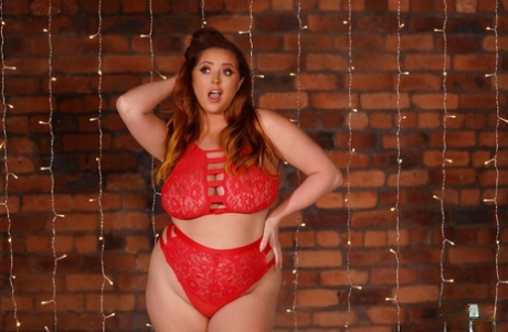 In her red lingerie, Chubby model Lucy Vixen displays her big tits and poses for a photo.