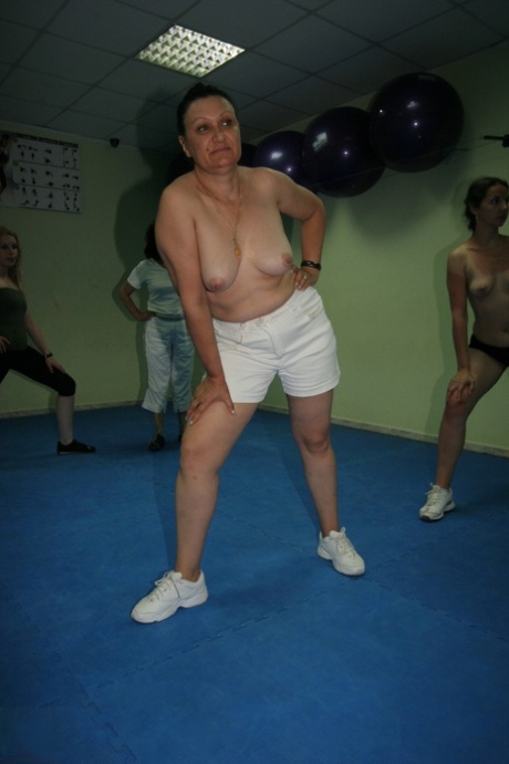 At a highly intense gym class, young female amateurs strip down and showcase their curves.