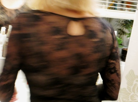 The amateur MILF, who has a curvy body, is caught on camera while changing and hiding behind a cover.