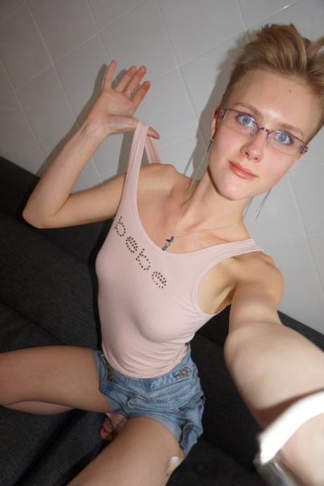 Homemade sexy selfie action: An amateur teenager with glasses fondles her cute tits.