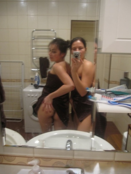 In the bathroom, sexy amateur lesbians take selfies while stripping and making out.