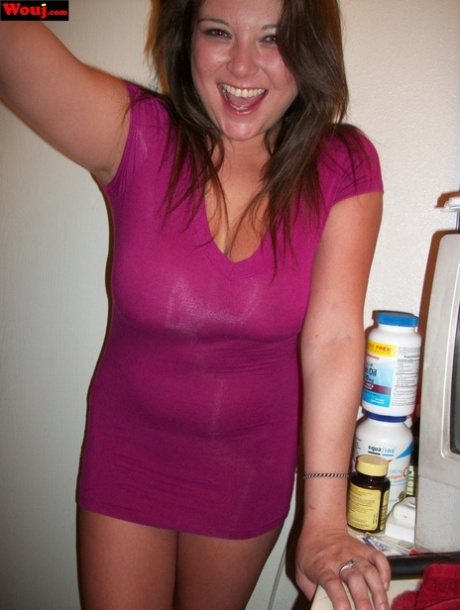 A shiny pink dress is worn by WouJ, the brunette amateur, to showcase her cleavage.