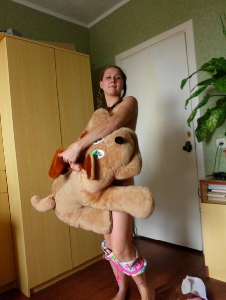 The naked amateur demonstrates her small hands while playing with her teddy bear.