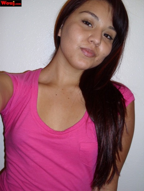 This steamy Asian female exhibits her sizable buttocks while wearing a pink shirt and not a bra.