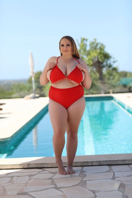 Sara Willis, a plump model, exposes her ample tits and restrains them by the pool.