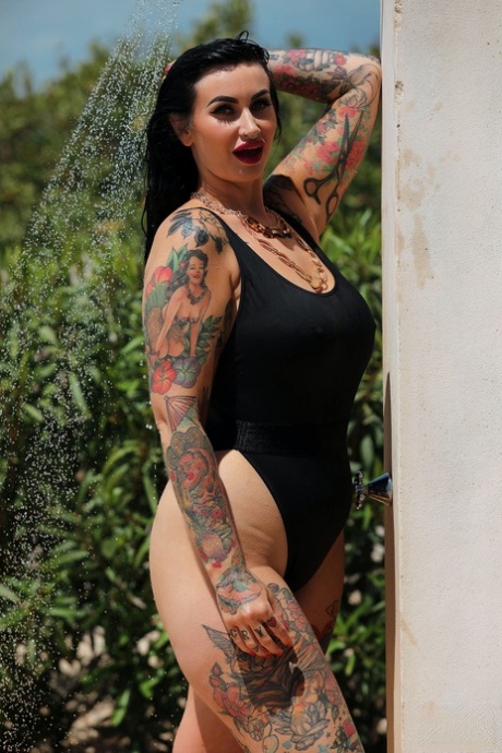 A naked and tattooed body is displayed by chubby babe Cherrie Pie outside as she poses for pictures.