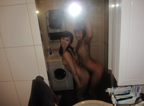 While exposing themselves to the mirror, brunette amateur girls taste each other's twats.