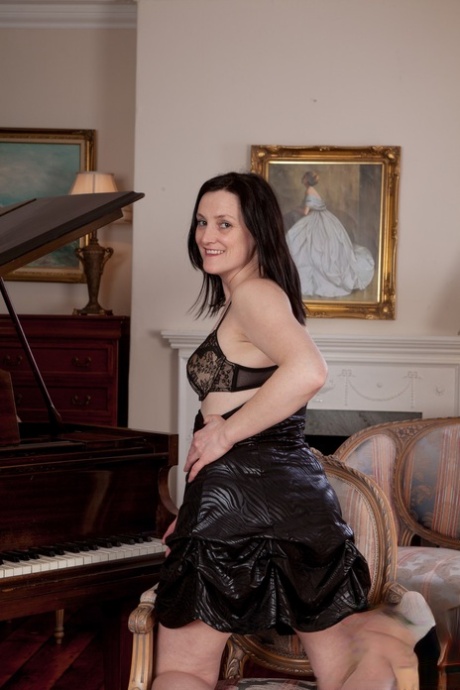 Emily Marshall, a curvy adult, removes her black attire and rubs her breasts.