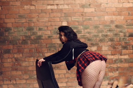Толстушка Кики показывает свои огромные дыни и позирует в сексуальной юбке и горячих чулках-сеточках