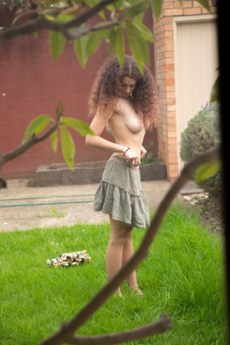 Naked nudity model Mina B exhibits her breasts and uncombed genital organ while dressing outside.