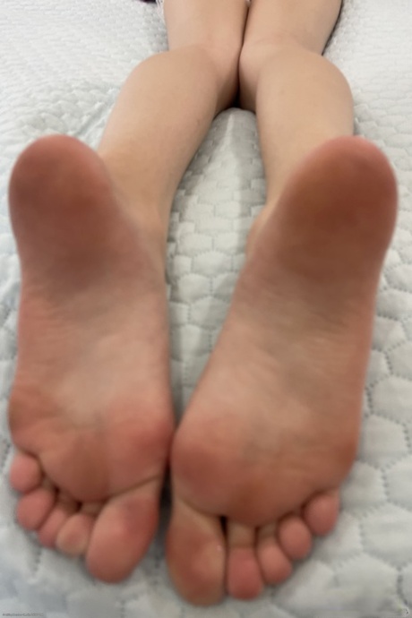 Skinny teen displaying her pretty feet and holes up close in a solo